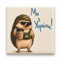 Cream square magnet with hedgehog in sunglasses and tactical vest carrying takeaway coffee under words Ми з України