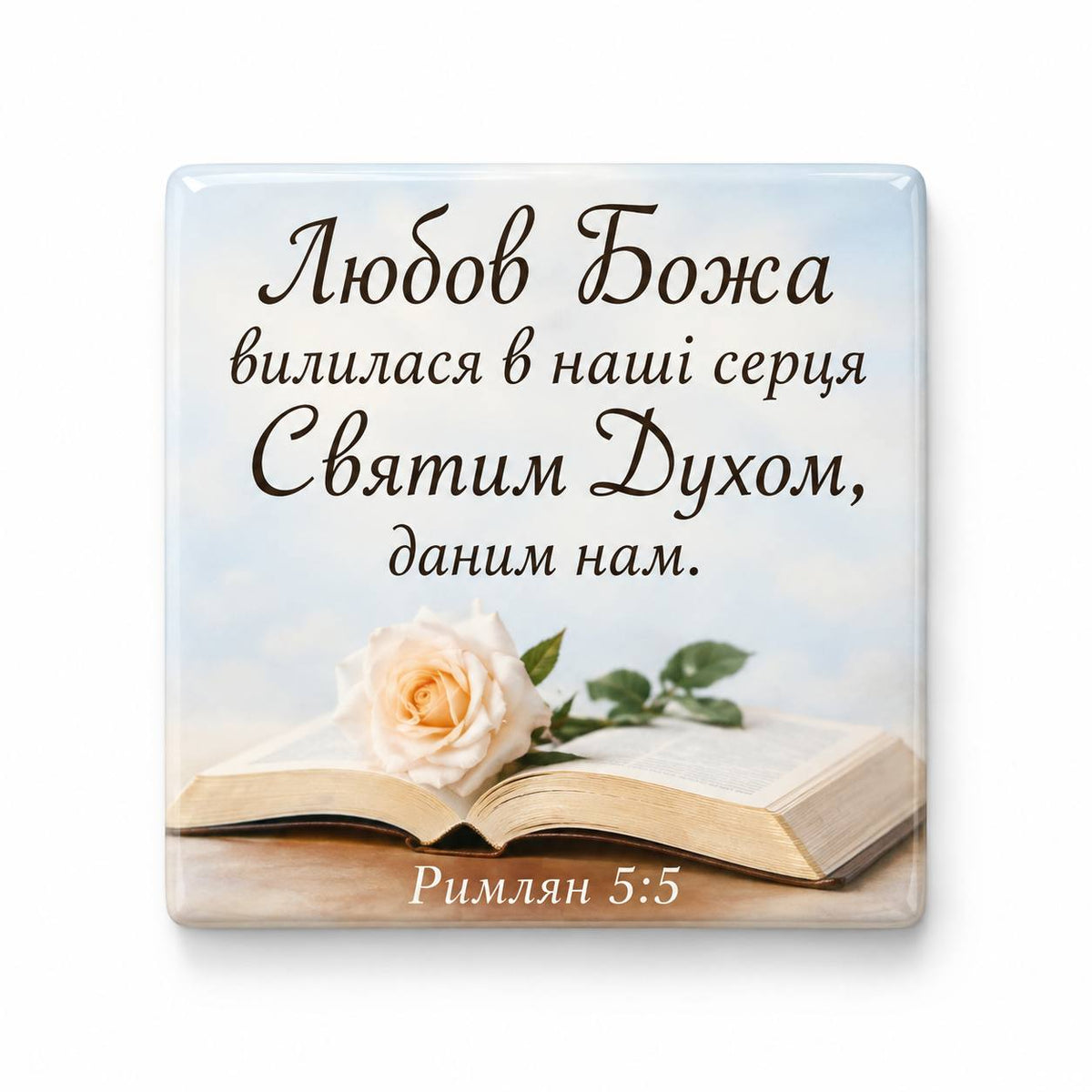 Romans 5:5 Ukrainian Bible verse above open Bible with cream rose