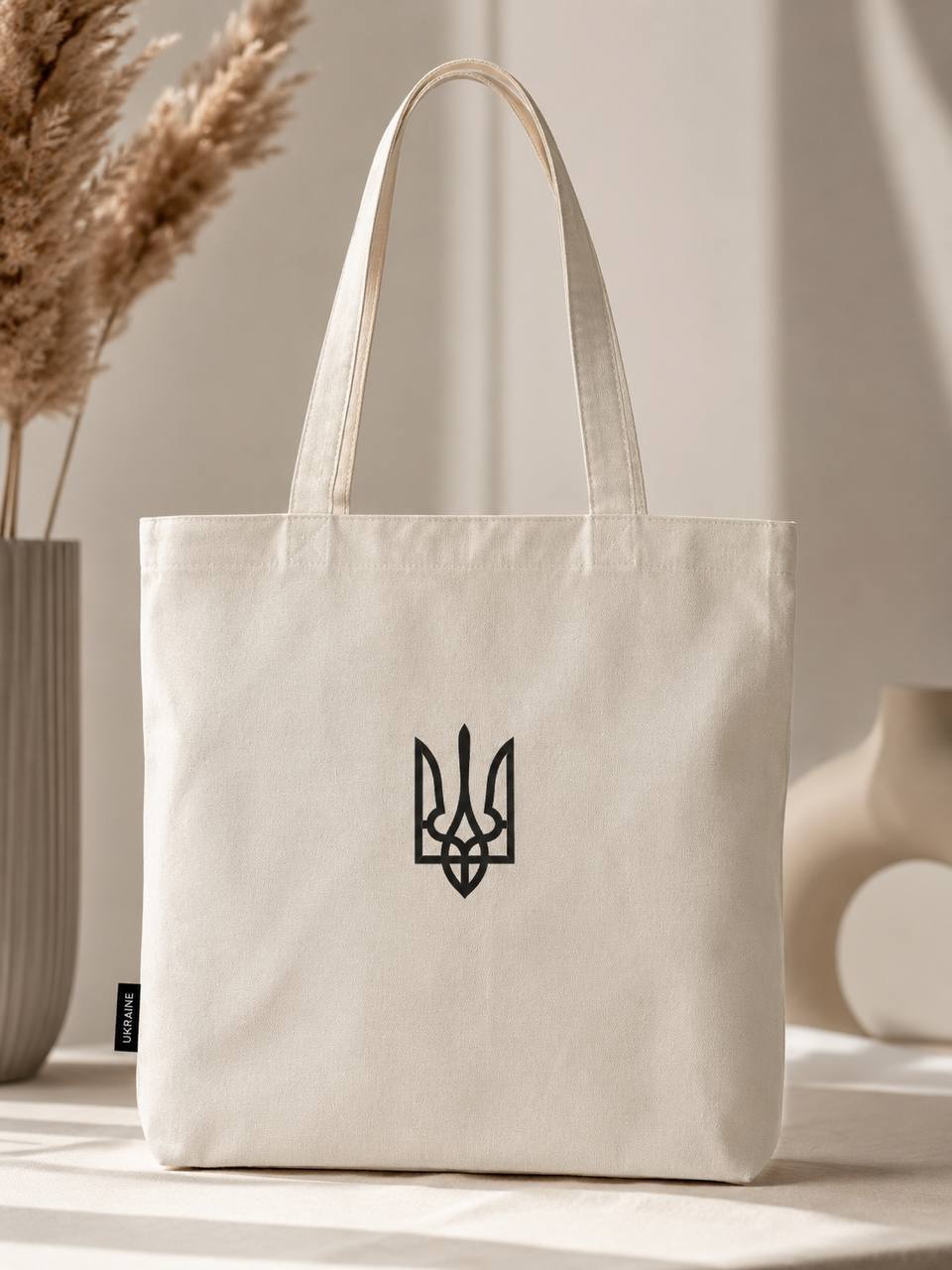 Natural-color tote bag with a small black Ukrainian trident